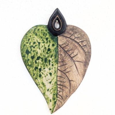  Handcrafted ceramic wall tile with natural leaf texture pressed into clay, minimalist and nature-inspired design